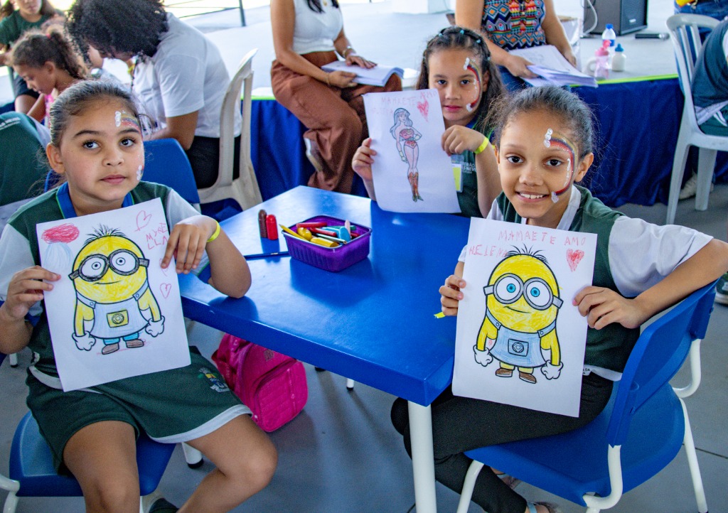 Estudantes mostrando seus desenhos coloridos em atividades pedagógicas